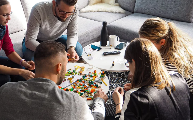 People on a table playing lego